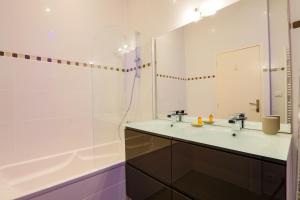 ein Badezimmer mit Waschbecken, Badewanne und Spiegel in der Unterkunft Duplex joliment décoré et sa cour ensoleillée in Saint-Martin-de-Ré + 12 Fotos