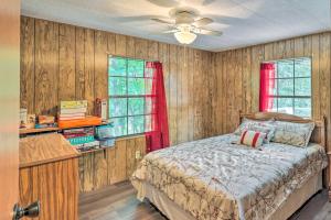 a bedroom with wooden walls and a bed with a red curtain at Suwannee Riverfront Home Grill, Near Springs in Branford
