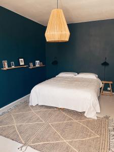 sypialnia z łóżkiem i niebieską ścianą w obiekcie Bô, Peace & Bordeaux w mieście Bordeaux