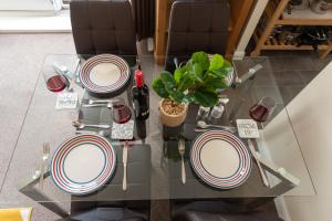 a glass table with chairs and plates on it at Neptune Marina in Ipswich