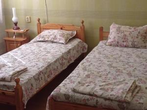 1 dormitorio con 2 camas y mesa con lámpara en Guest House Sunrise, en Shabla