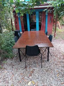 a wooden table with a black chair around it at Casa de campo, surf, pesca y golf in Miramar