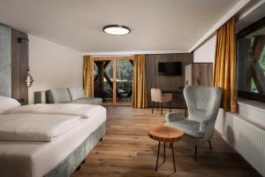 ein Hotelzimmer mit Bett, Tisch und Stuhl in der Unterkunft Hotel Das Kohlmais - direkt an der Kohlmaisbahn JOKERCARD inklusive in Saalbach-Hinterglemm