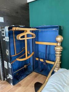 a blue suitcase sitting next to a bed at Gleis 1, Eisenbahn Waggon mit Whirlpool und Ofen in Dahlem