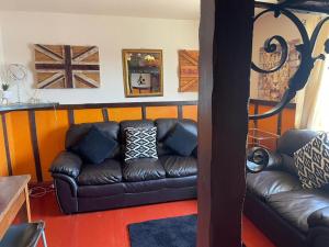 ein Wohnzimmer mit einem braunen Ledersofa in der Unterkunft Yarm Cottages Sleeping 6 Forge and Smythy in Kirk Leavington + 42 Fotos