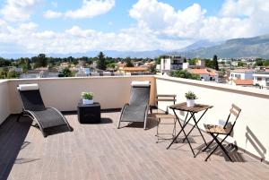 eine Terrasse mit Stühlen und einem Tisch auf dem Dach in der Unterkunft Palermo Holidays in Mondello
