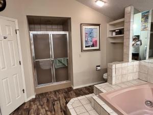 a bathroom with a shower and a tub and a sink at Greens One Vacation Home 40 in Bella Vista +24 photos