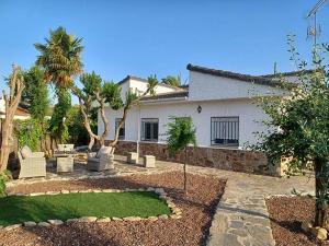 a house with a yard with a garden with trees at Chalet independiente con amplio jardín y barbacoa AT - CC-00678 in Puerto Rey