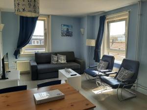 - un salon avec un canapé, des chaises et une table dans l'établissement Appartementen Zandvoort, à Zandvoort