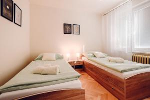 2 camas individuales en una habitación con ventana en Apartmán Dobré ráno, en Banská Štiavnica