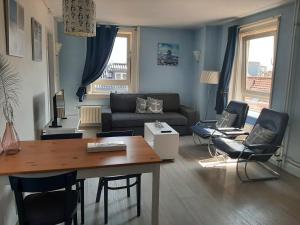- un salon avec un canapé, une table et des chaises dans l'établissement Appartementen Zandvoort, à Zandvoort