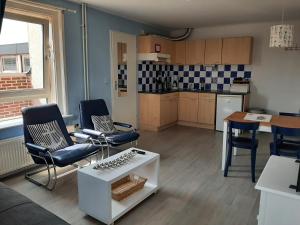 ein Wohnzimmer mit Stühlen und einem Tisch sowie eine Küche in der Unterkunft Appartementen Zandvoort in Zandvoort