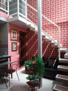 a living room with a staircase and a red wall at Studio Bangalô Belém Hospedagem in Belém