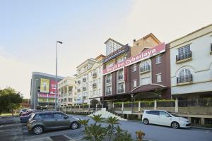 a parking lot with cars parked in front of a building at Beryll Inn Cyberjaya Hotel in Cyberjaya