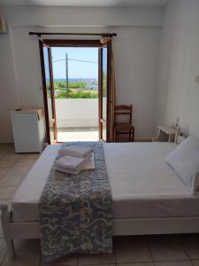 a bedroom with a bed with a view of the ocean at Afendra Hotel in Skiros