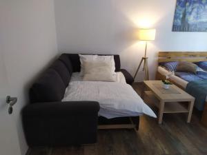 a living room with a bed and a couch at PISQOR Apartment - self check-in in Bratislava