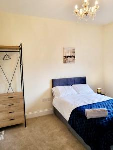 a bedroom with a large bed and a chandelier at 5 Bedroom house in great location, near stadium NN5 in Upton