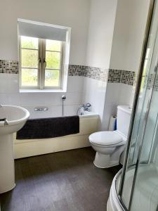 een badkamer met een bad, een toilet en een wastafel bij 5 Bedroom house in great location, near stadium NN5 in Upton