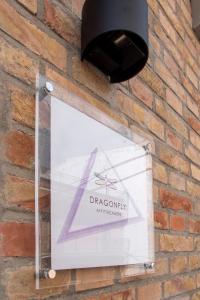 um sinal no lado de uma parede de tijolos com uma luz em Dragonfly affittacamere em Motta Montecorvino