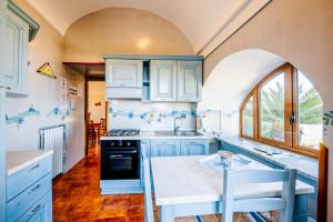 a kitchen with white cabinets and a sink and a stove at Appartamento Anna in Villa Laura in Scala