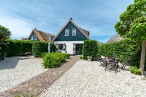 uma casa com uma mesa e cadeiras no quintal em Buitenplaats 103 Callantsoog em Callantsoog