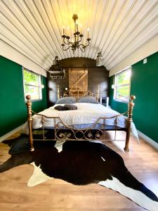 Gleis 1, Eisenbahn Waggon mit Whirlpool und Ofen في Dahlem: غرفة نوم بسرير كبير في غرفة بجدران خضراء