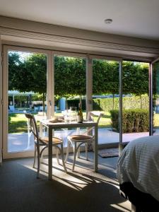 una camera da letto con tavolo e sedie di fronte a una finestra di Gardenhouse 'The Block' - Ostend - private garden - IR cabine - AC a Ostenda