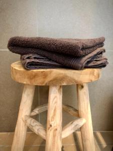 una pila de toallas sobre un taburete de madera en Gardenhouse 'The Block' - Ostend - private garden - IR cabine - AC en Ostende
