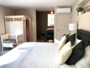 1 dormitorio con 1 cama blanca grande y sofá en Gardenhouse 'The Block' - Ostend - private garden - IR cabine - AC en Ostende