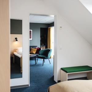 a hotel room with a bed and a mirror at 62N Hotel - City Center in Tórshavn