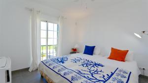 a bedroom with a bed with blue and white sheets and a window at Vila Castro-Cleverdetails, Quiet area, private pool in Vilamoura +40 photos