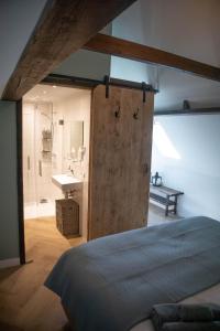 Schlafzimmer mit einer Holztür, die zu einem Bad führt in der Unterkunft B&B de Olde Hilde in Eibergen