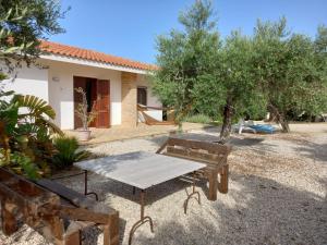 tavolo da picnic e panca di fronte a una casa di Casa vacanza Nocellara a Menfi