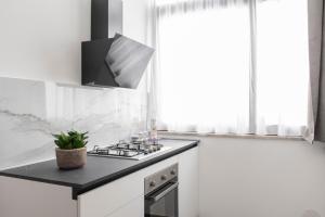 Una cocina blanca con estufa y ventana. en FONTANELLE HOME, en Trapani 8 fotos más