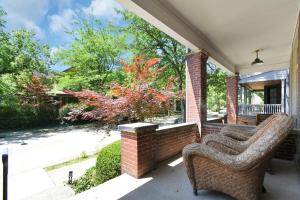 a porch with a wicker chair on a house at Modern Boho Stylish 1BR Near DT on Historic Street in Columbus