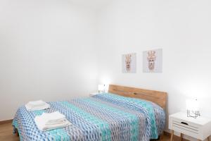 1 dormitorio con 1 cama con edredón a rayas en FONTANELLE HOME, en Trapani