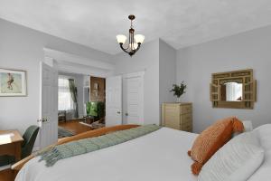 um quarto com uma grande cama branca e um lustre em Modern Boho Stylish 1BR Near DT on Historic Street em Columbus