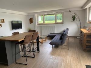 a living room with a table and some chairs at Le clos des Pommiers Fuji in Uffholtz