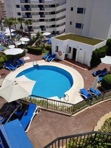 an overhead view of a swimming pool with chairs and umbrellas at Apartamento Los Patos Beach in Benalmádena