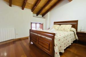1 dormitorio con 1 cama y suelo de madera en Apartamentos Rurales LLeguera en Llanes