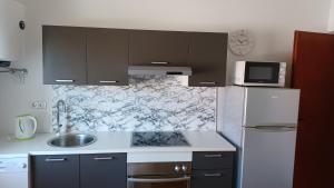 a kitchen with a white refrigerator and a microwave at Apartments Pavelić in Crikvenica