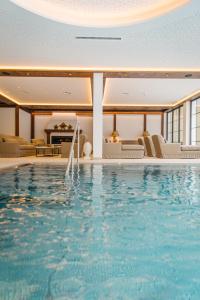 a large swimming pool in a room with furniture at Hotel Bräu in Zell am Ziller