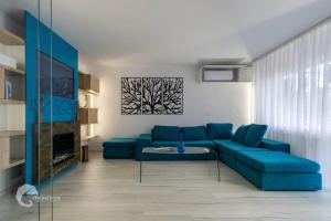 sala de estar con sofá azul y mesa en Apartament luxos în Onești, en Onești