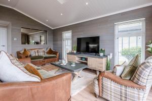 a living room with two couches and a tv at Briargate, Aldeburgh in Aldeburgh