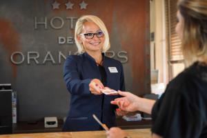 a woman is handing out food to a woman at The Originals Boutique, Hôtel des Orangers, Cannes (Inter-Hotel) in Cannes