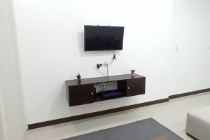 a living room with a tv on a white wall at Hermoso Departamento - Zona Miraflores in Tarija