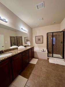 a large bathroom with two sinks and a shower at Luxury Legacy West Townhouse in Plano