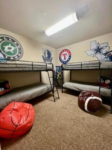 a room with two bunk beds and a football wall at Luxury Legacy West Townhouse in Plano