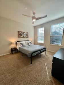 a bedroom with a bed and a ceiling fan at Luxury Legacy West Townhouse in Plano