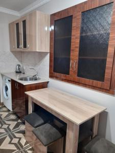 a kitchen with a wooden table and a sink at Alex BnB in Tatʼev